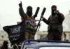 What Do We Know About the Dirty War on Syria? Masked armed militants standing on pickup with flag