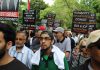Canada’s Hidden Fundamentalism Protesters holding signs in a crowded street rally.