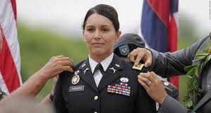 Tulsi Gabbard on Idlib A female military officer receiving a medal during a ceremony.