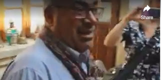 Aleppo Did Not “Fall”. It was Liberated. Interview with Mr. Abdel Kaddour An elderly man wearing glasses and a scarf smiles indoors.