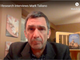 A man in a blazer during a virtual interview.