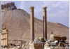 Syria and Syrians Restore Our Common Heritage/ By Rida Ali Ruins of ancient columns with a mountainous backdrop.