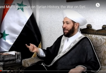 Al Qaeda Court in Damascus Sentences former Grand Mufti to Life Imprisonment/ Vanessa Beeley A man in traditional Islamic attire speaks in an interview setting.