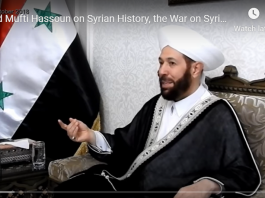 A man in traditional Islamic attire speaks in an interview setting.