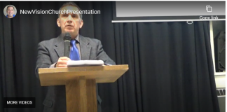 Who am I? Man delivering a speech behind a wooden podium with a microphone.