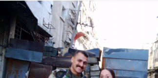 Eva Bartlett Reporting from Aleppo/November 5 and 6, 2016 Two soldiers in military uniforms stand in an urban street.
