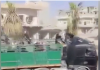 Fighters from US-backed SDF describe unimpeded ISIS exodus from Raqqa on their watch/RT A man on a motorcycle rides alongside a large truck on a city street.
