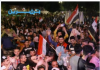 Aleppo, Syria Crowd waving flags during a lively night celebration.
