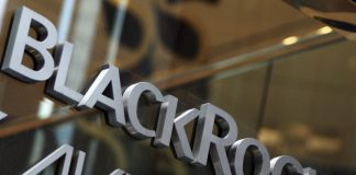 The Same Shady People Own Big Pharma and the Media/ By Dr. Mercola Close-up of glass door with 'BlackRock' and 'Avenue' text.