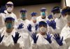 COVID-19: Where Is the Virus? British Medical Journal (BMJ)/ By Janet Menage Healthcare workers in full protective gear waving at the camera.