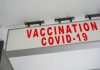 Imperial College and the “Vaccine Revolution” Red COVID-19 vaccination sign on a white wall.