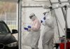 Over 4,600 Doctors and Scientists Sign “Rome Declaration” Accusing COVID Policy-Makers of ‘Crimes Against Humanity’ Healthcare workers in full PPE attending to a car at a testing site.