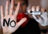 COVID mRNA shots are a ‘technology designed to poison people’: Canadian doctor Person refuses COVID-19 vaccine, showing a hand with 'No' written on it.