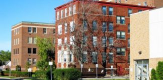 FDA & CDC Ignore Damning Report 90+% of Hospital’s Admissions Were Vaccinated for COVID-19 A red brick apartment building on a sunny day.