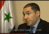 Aleppo renaissance: the war and Syrian industry A man speaking in an interview with a partially visible flag in the background.