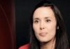Ontario doctor resigns over forced vaccines, says 80% of ER patients with mysterious issues had both shots/ By Kennedy Hall Close-up of a woman with long dark hair against a dark background.