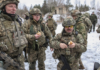 Foreign Fighters Flee from Ukraine/By Paul Antonopoulos Soldiers in camouflage gear eating outdoors in winter.