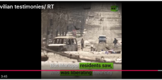 The Liberation of Mariupol Military vehicles and soldiers in a war-torn street scene.