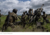 US Veterans: If NATO Didn’t Want Ukraine Grid Hit, It Shouldn’t Have Taken Part in Kiev’s Offensive/By Ekaterina Blinova Soldiers in combat gear operating artillery in a field under cloudy skies.