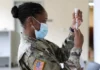 RFK Jr :138 Companies Involved in COVID Vaccine. “They’re all military contractors.”/ By Alexandra Bruce A soldier in uniform preparing a syringe while wearing a mask.