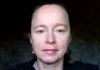 Pharma Insider Sounds the Alarm on mRNA Vaccines in the Food Supply Portrait of a woman with a neutral expression against a dark background.