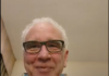 Dr. Shoemaker on Jab-Induced Myocarditis Smiling elderly man with white hair and glasses indoors.