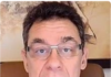 Pfizer CEO: “by 2023 we will reduce the world population by 50%” Man wearing glasses in a close-up video call frame.
