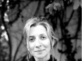 Black and white portrait of a woman smiling gently.