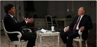 Russian President Vladimir Putin bursts the bubble of Western “Perception Managers” Two men in suits sit opposite each other during a formal discussion in an elegant room.