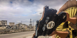 Holy SH*T! ISIS created real ZOMBIE soldiers in Syria BBC warns, U.S. should invade! | Redacted News A damaged street sign with Arabic text in a war-torn area.