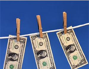 Who are the Narco-Terrorists: Donald Trump is Threatening to Wage War on Venezuela and Colombia/By Prof Michel Chossudovsky Three one-dollar bills hanging on a clothesline with clothespins.