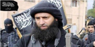 Al-Nusra Leader Meets CIA Officials Man in military gear with a black beard and head covering.