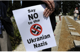 A protest sign saying 'Say NO to the Ukrainian Nazis' with a crossed-out swastika.
