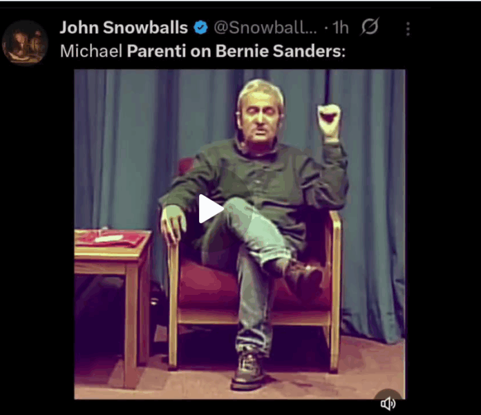 Seated speaker gesturing in chair on stage