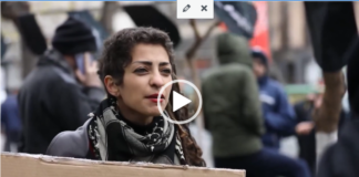 War Against Imperialism Woman at protest holding cardboard sign