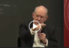 Evil Empire/ Prof. John Mearsheimer Bald man in suit pointing during discussion