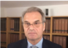 Free Reiner Fuellmich – The Documentary Man in suit and glasses, bookshelf background