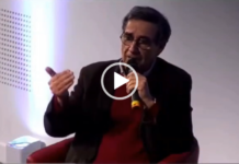 L’Iran Des Mollahs Uniquement? Seated speaker gesturing while holding microphone